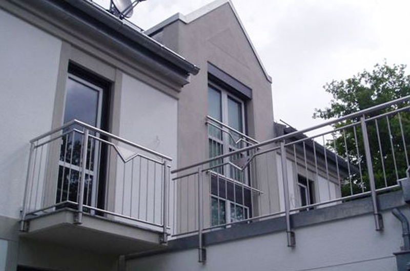 Metallzaun eines Balkons von einem weißen Haus